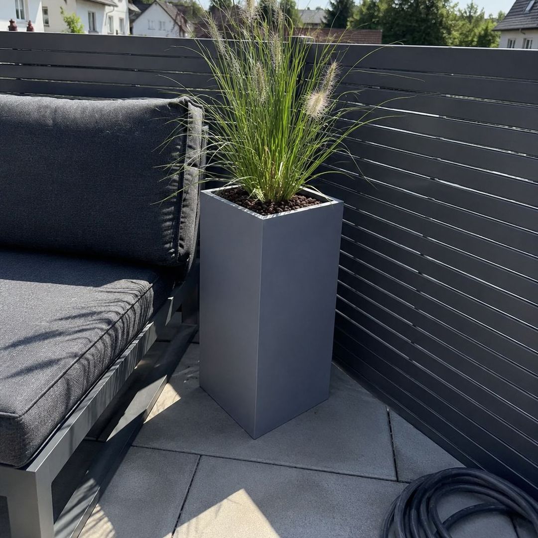 Pflanzkübel Fiberglas Säule 30x30x68cm grau mit Lampenputzergras auf Terrasse [KI-Lifestyle]