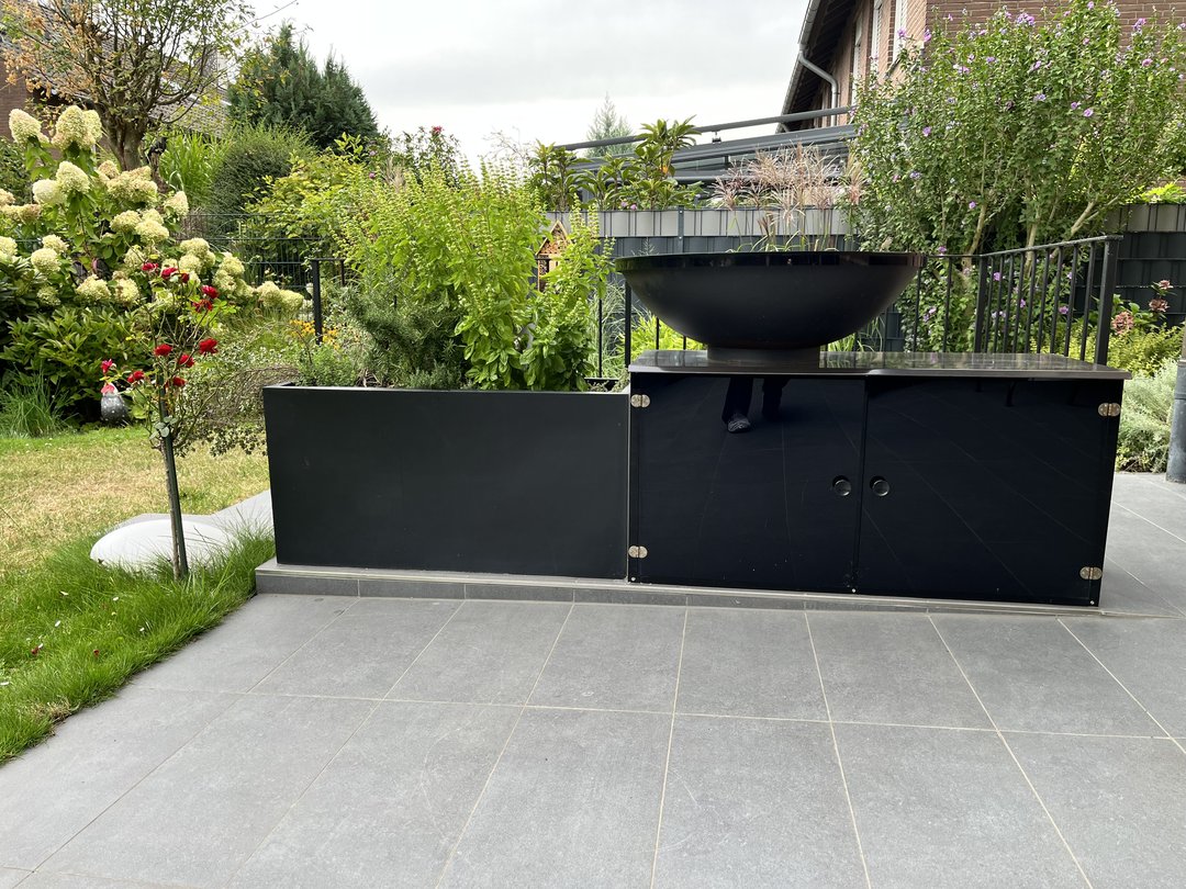 Pflanzkübel Fiberglas rechteckig 100x40x50cm elegant schwarz-matt mit Kräuterbepflanzung neben einer Feuerschale auf einer Gartenterrasse